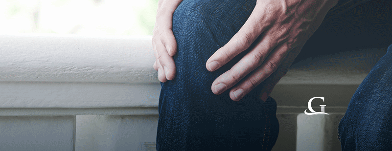 Man Holding Knee In Pain Stock Photo