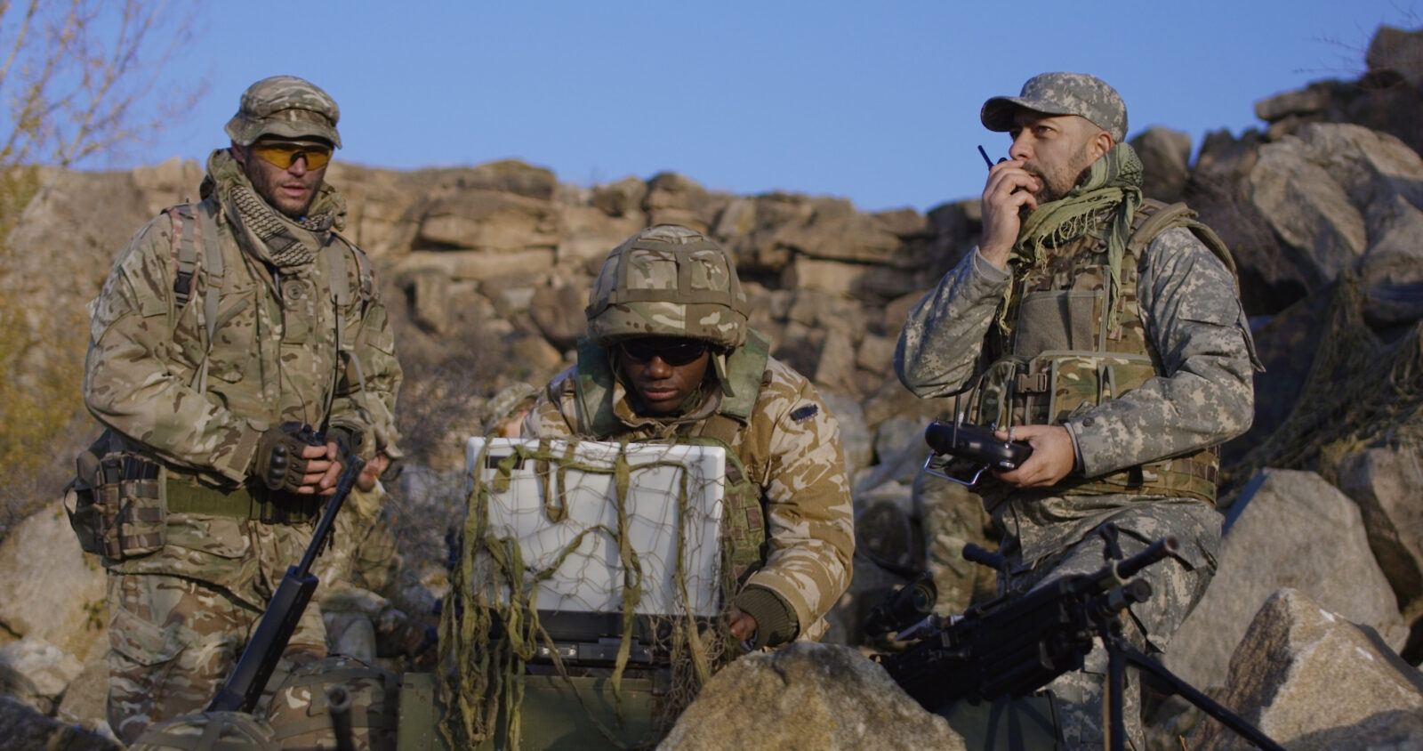 Armed african american soldier looking at a computer