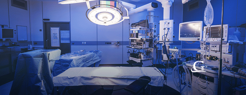 Empty hospital operating theatre with lighting over bed