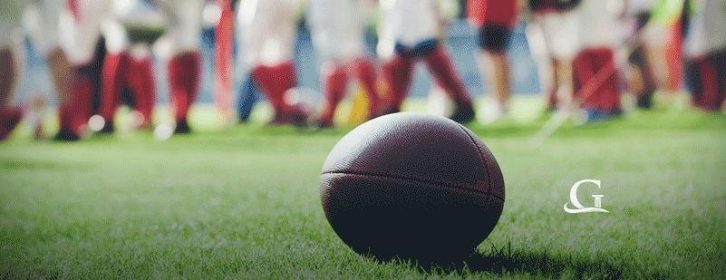 Football Laying On The Grass During A Football Game Stock Photo