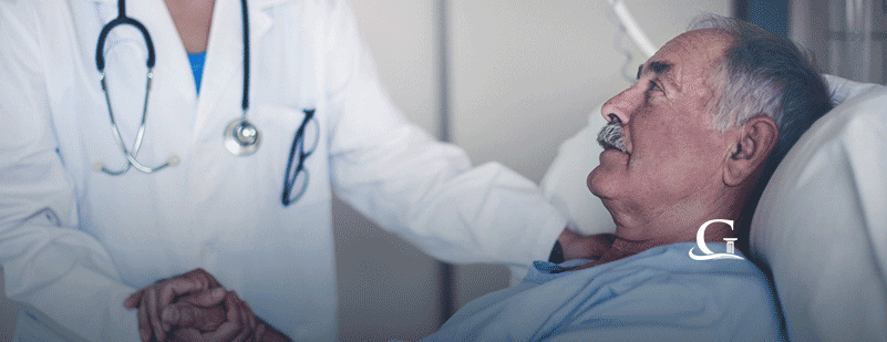 Doctor Speaking With Elderly Patient In Hospital Bed Stock Photo