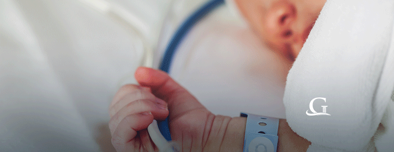 Baby Laying In An Incubator At The Hospital Stock Photo