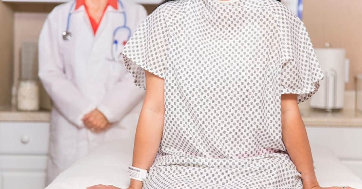 Female Patient Sitting On A Hospital Bed Stock Photo