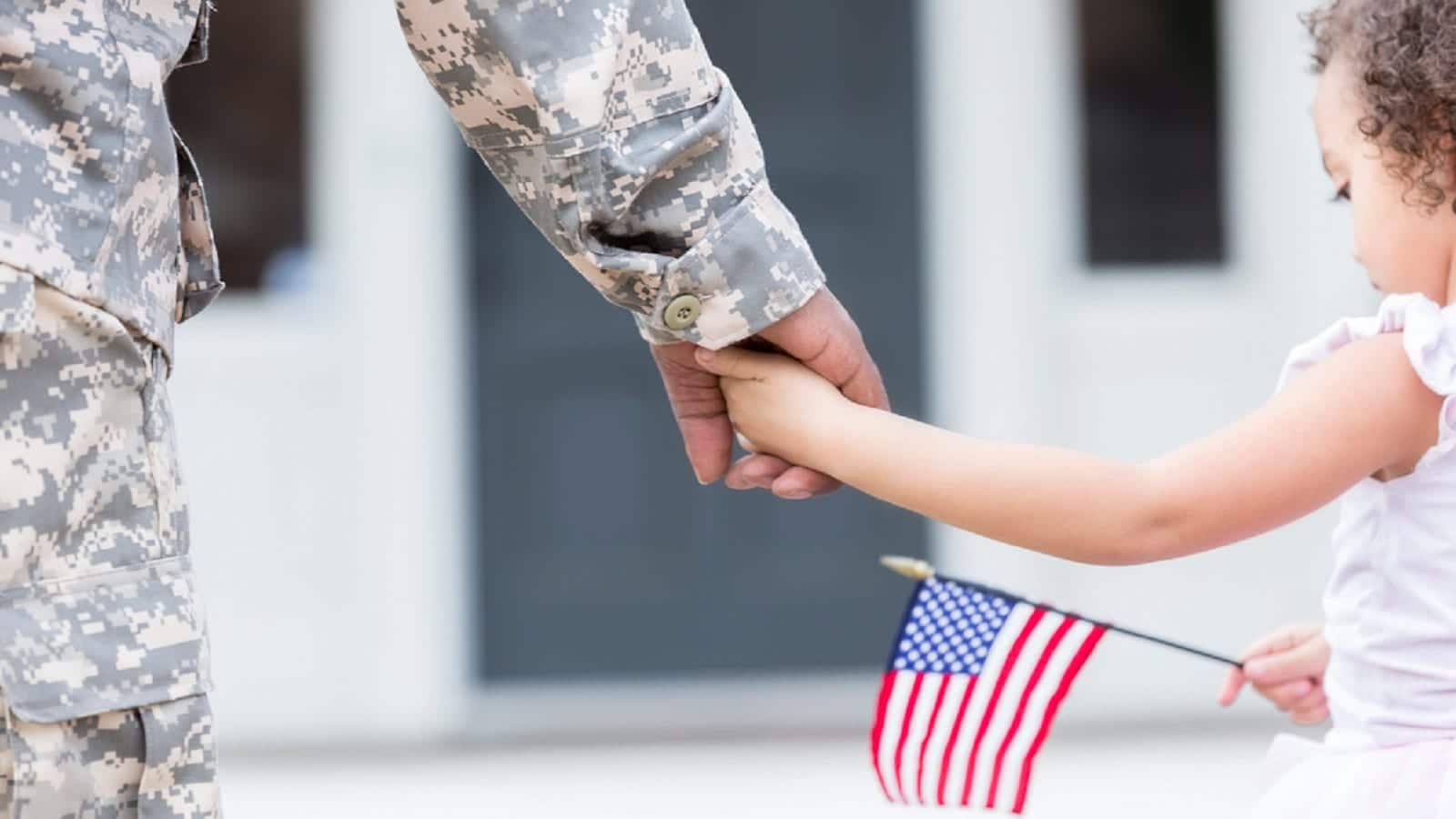 Soldier Holding Hands With Young Daughter Stock Photo