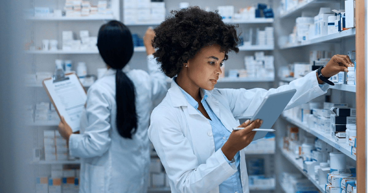 Female Pharmacist Examining Medication Bottles Stock Photo